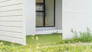 A modern building with a white exterior, a visible window, and a small grassy area in front. - Gyeongju Purspet Dog Pension (Gyeongju)