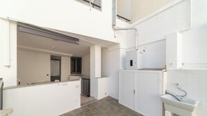 Una cocina limpia y moderna con armarios blancos, horno empotrado y salpicadero de azulejos.
