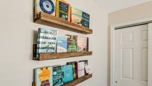 Three wooden shelves with books. - Newly Listed Ocean View and Dog Friendly Condo on Oak Island (Oak Island)