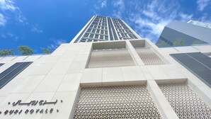A modern building with a prominent sign reading "BURJ ROYAL" and a geometric facade. - Burj Royale Elegance Cityscape From Your Balcony (Dubai)