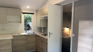 A compact kitchen with a window, built-in cabinets, a sink, and a stove.