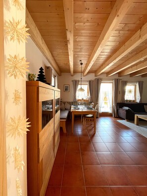 A wooden interior with a dining area, a sofa, and a bench.