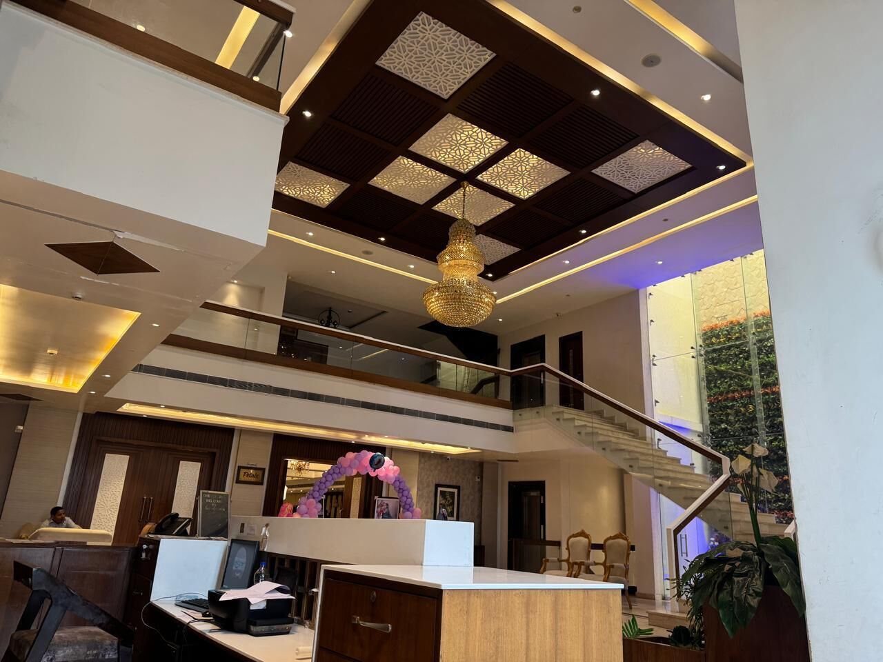 Eine Hotelhalle mit Empfangstresen, einer Treppe und einem dekorativen Bogen.