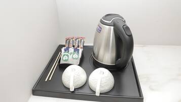 A tray with a coffee maker, tea packets, and two golf balls.
