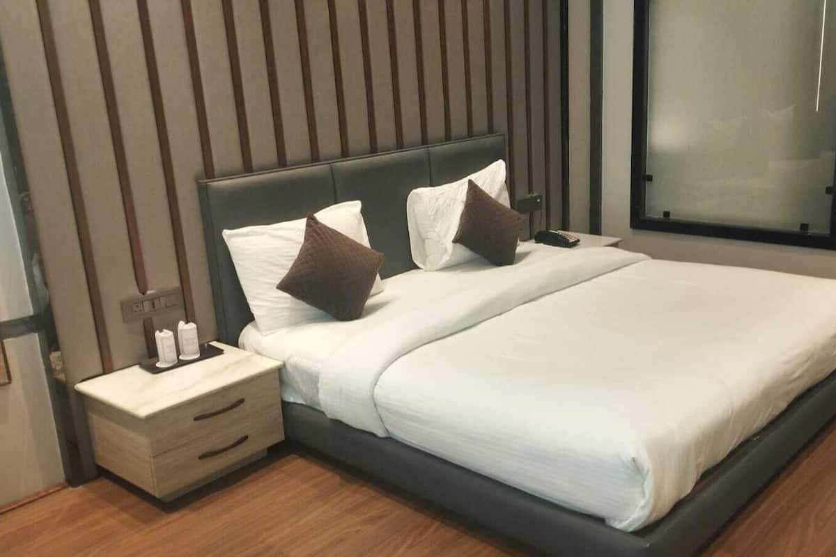Une chambre à coucher moderne avec un grand lit, une table de chevet et une commode.