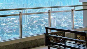 A high-rise room with a large window overlooking a cityscape. - 2BR Gem in MNL w/Pool, Fast WiFi, Netflix Near Luneta US Embassy & Intramuros (Manila)