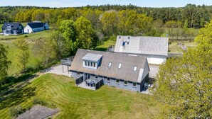 Une grande maison moderne dotée d’un vaste patio et d’un grand garage.