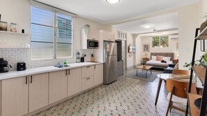 Una cocina moderna con una isla grande, electrodomésticos de acero inoxidable y un salpicadero de azulejos.