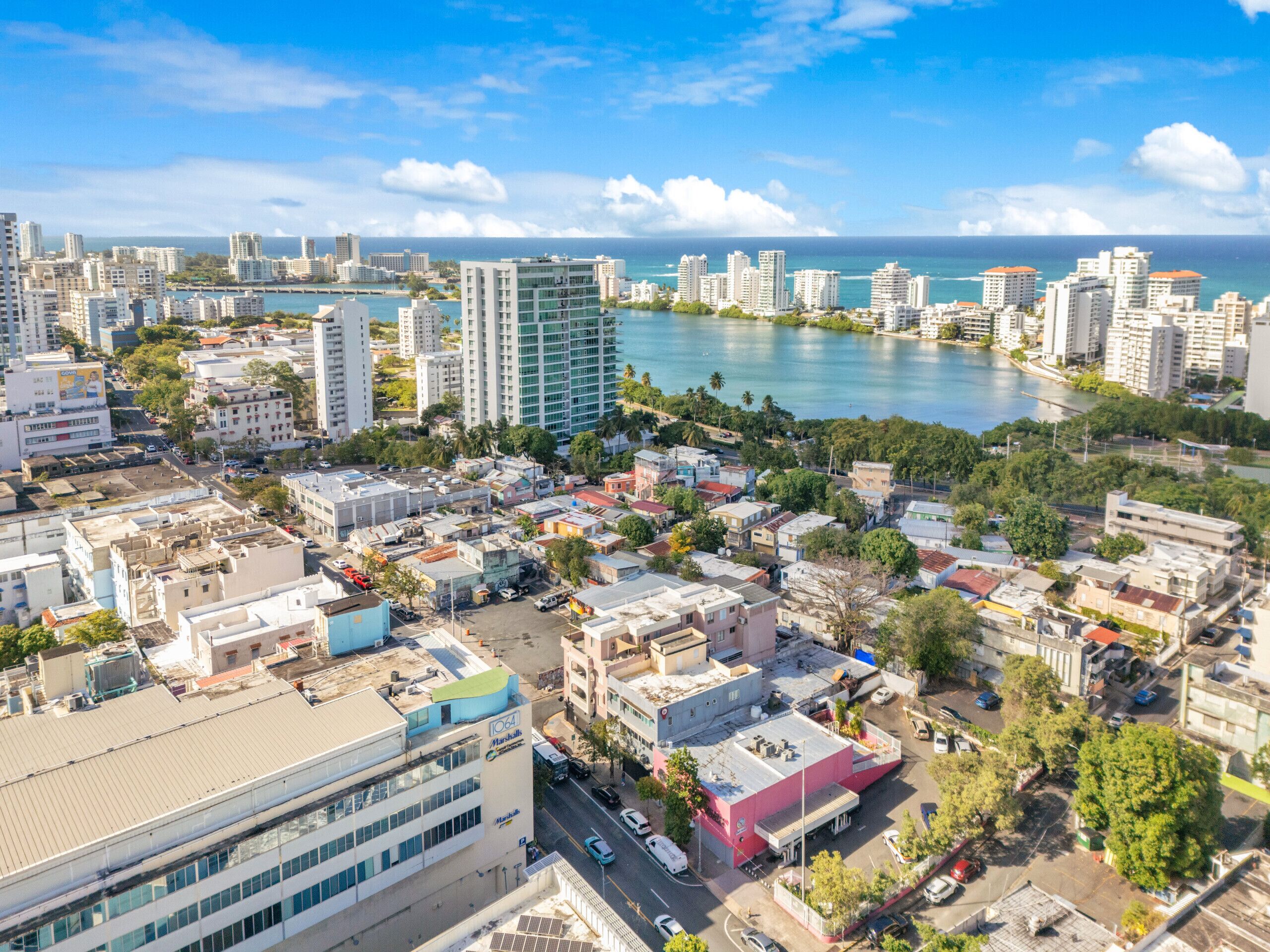 Un paysage urbain côtier avec de hauts immeubles, une marina et un mélange de bâtiments résidentiels et commerciaux.