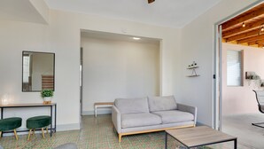 A modern living room with a grey sofa, a coffee table, and a patterned floor. - Fancy Rooftop Retreat in a Central Spot of Miramar (San Juan)