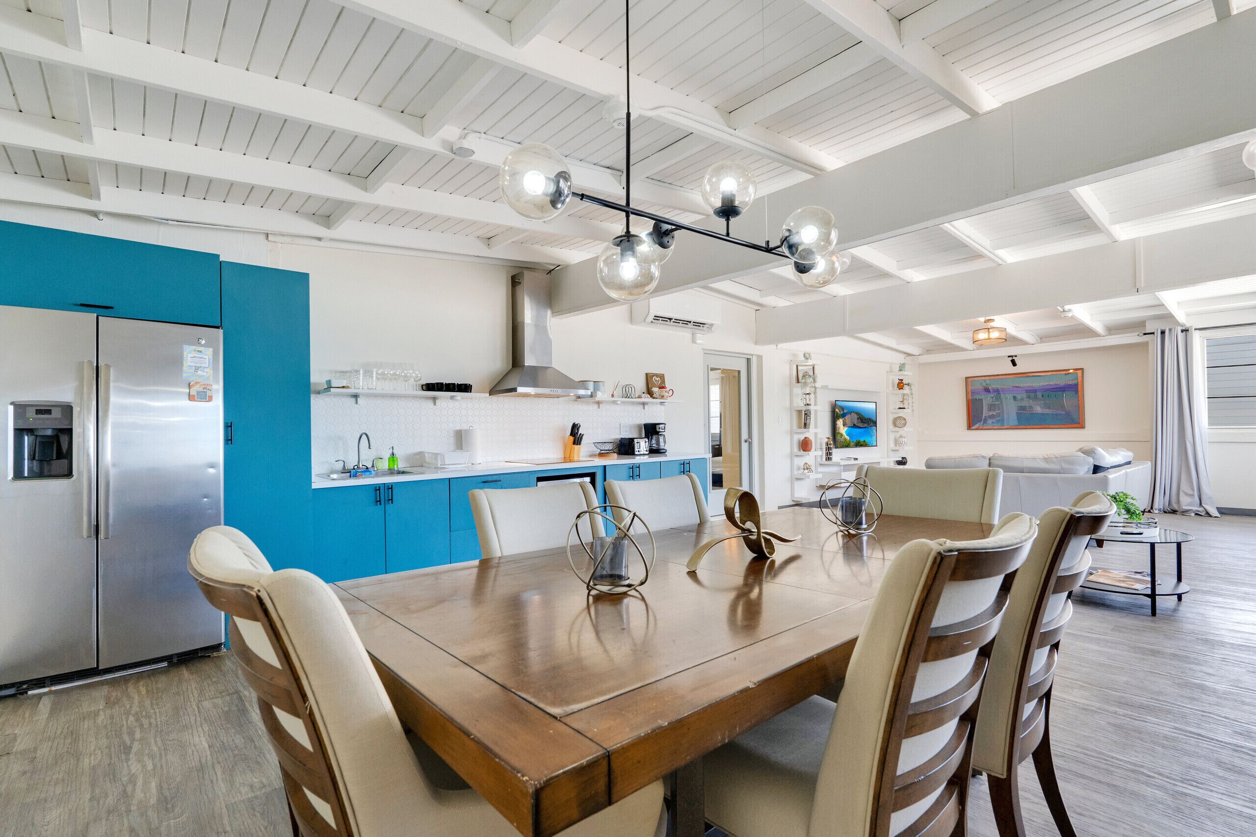Una cocina moderna con una isla central, armarios azules y un refrigerador de acero inoxidable.