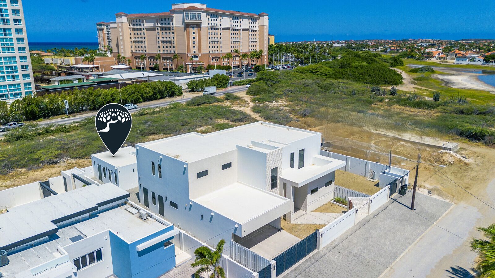 A modern building with a flat roof and a large parking area.