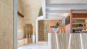 A spacious lobby with a stone wall, a reception desk, and a kitchen area in the background. - Bed & Breakfast in Maglie with 1 bedrooms sleeps 2 (Maglie)