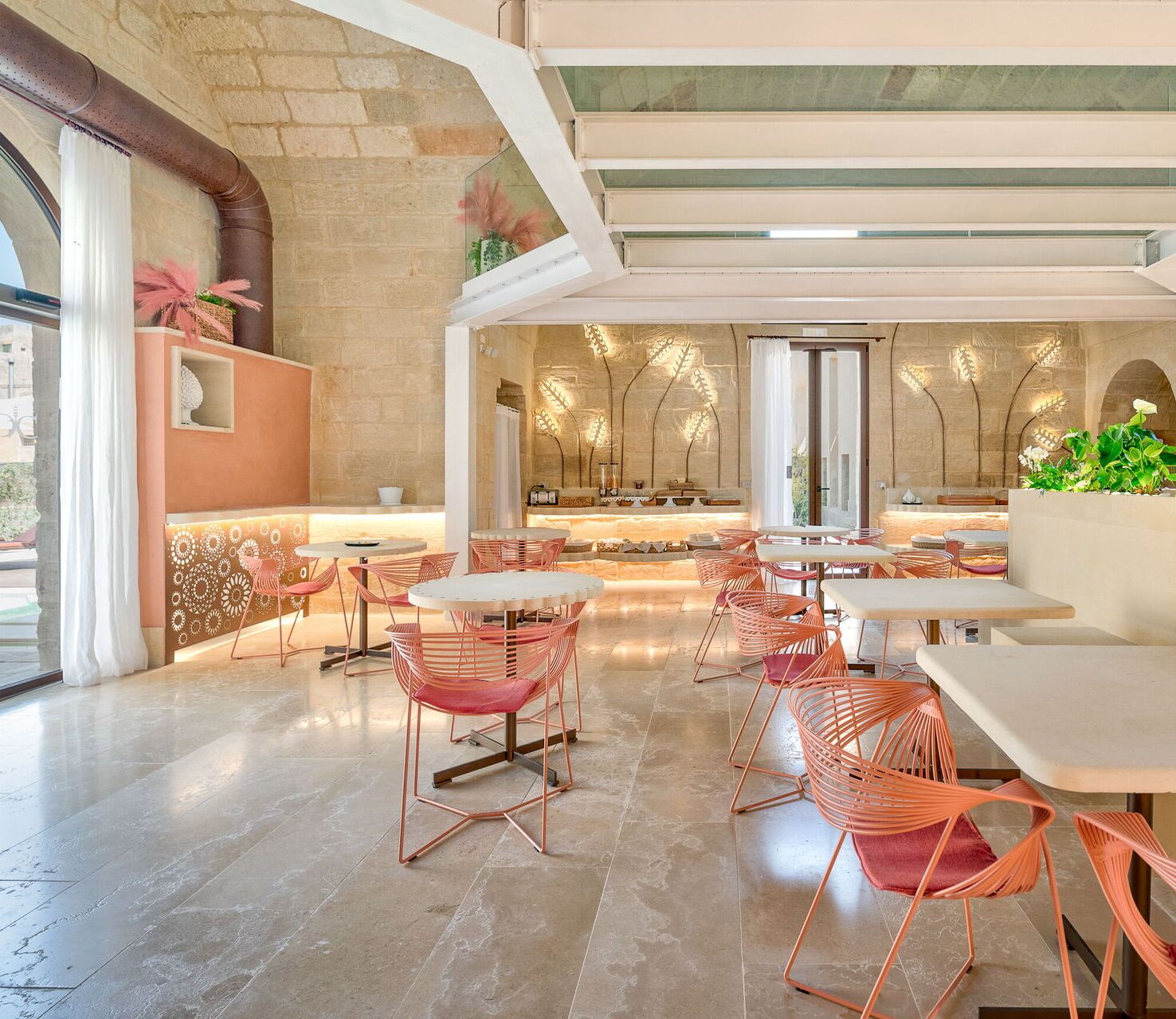 Un espace repas moderne avec des tables et des chaises rondes, un bar et une vue sur l’extérieur.