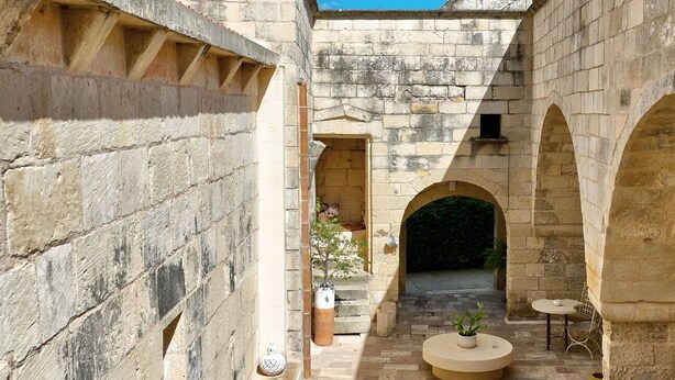 A courtyard with stone walls, arches, and a central seating area with tables and chairs. - Bed & Breakfast in Maglie with 1 bedrooms sleeps 2 (Maglie)