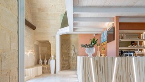 A spacious lobby with a stone wall, a reception desk, and a kitchen area in the background. - Bed & Breakfast in Maglie with 1 bedrooms sleeps 2 (Maglie)
