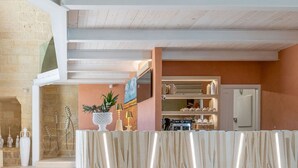 Eine geräumige Lobby mit Steinwand, einer Rezeption und einem Küchenbereich im Hintergrund.