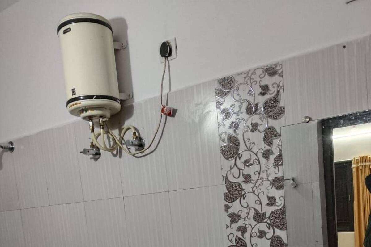 Ein Badezimmer mit Toilette, Waschbecken und Wanddurchlauferhitzer.