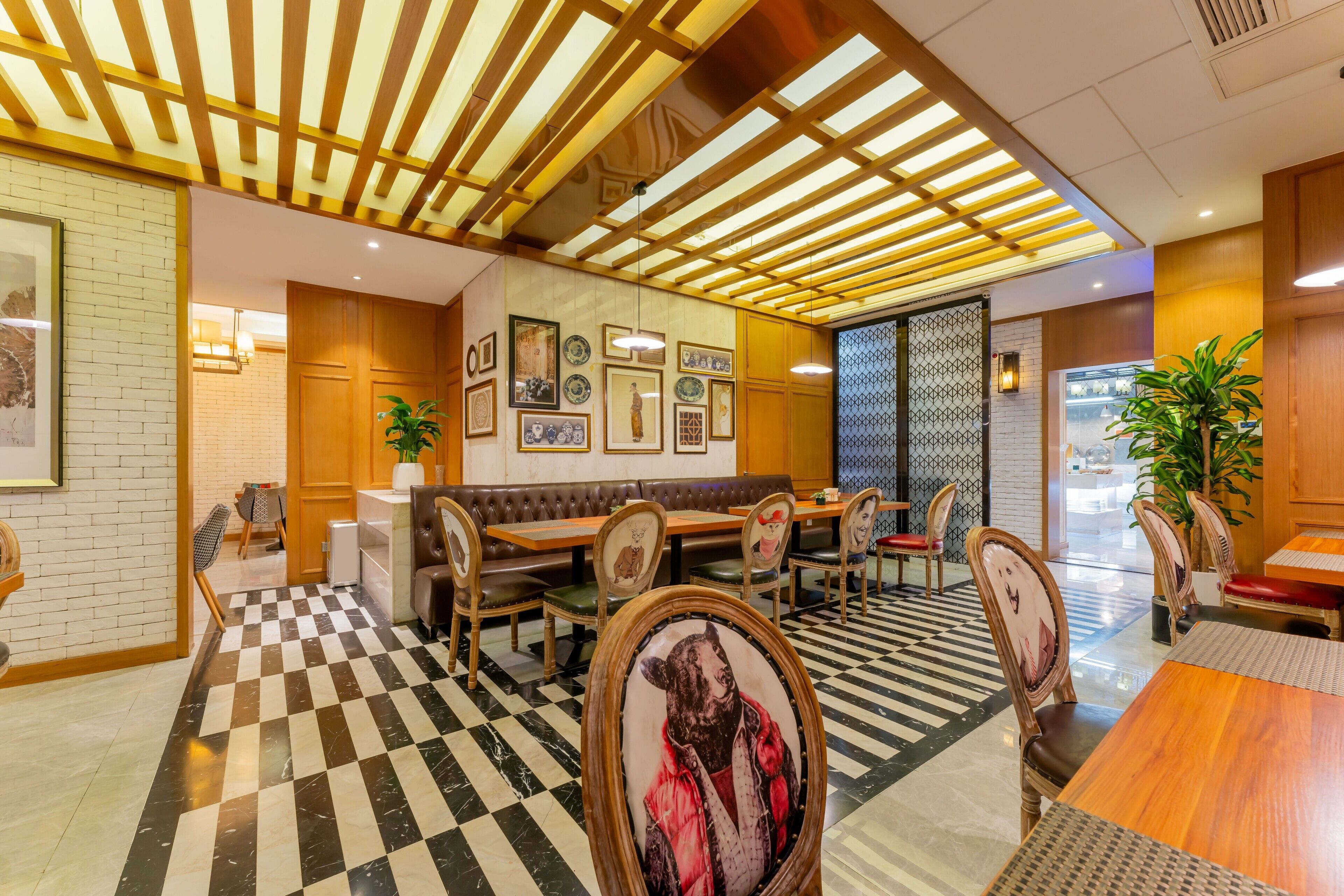 A restaurant with a checkered floor, wooden ceiling beams, and framed artwork on the walls.