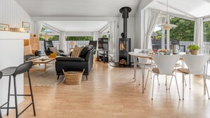 A spacious living area with a fireplace, a dining table, and comfortable seating. - "Henri" - 1.2km from the sea by Interhome (Hjørring)