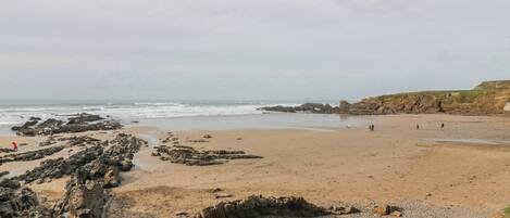 A beach with rocky formations and a sandy shore.