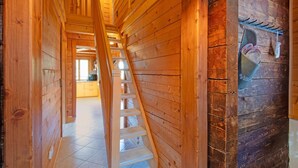 Interior de madera con una escalera de madera que conduce a una habitación.