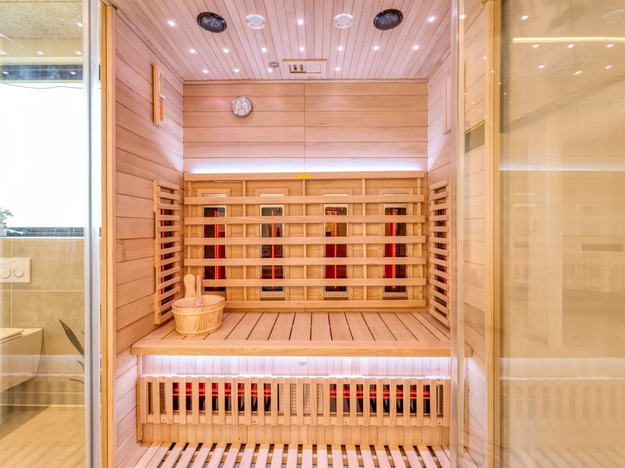 Een sauna met houten banken en een houten bank bij de ingang.