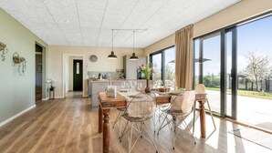 A spacious kitchen with a dining area, large windows, and a view of the outdoors. - "Edvia" - 200m to the fjord by Interhome (Holbæk)