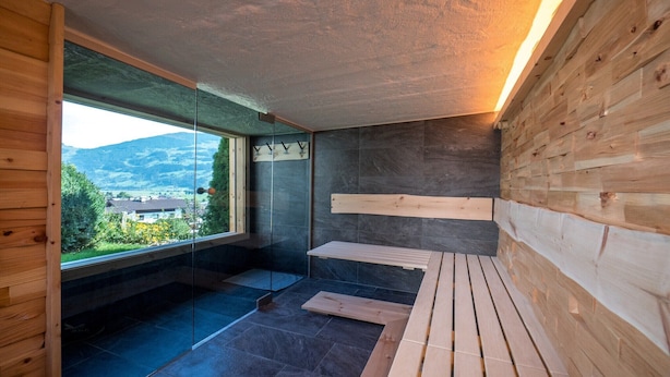 A modern room with a glass wall, wooden paneling, and a view of the outdoors. - Chalet in Fügen near Spieljoch Ski Lift (Fügen)