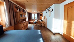 Un interior de madera con una cama, comedor y cocina.