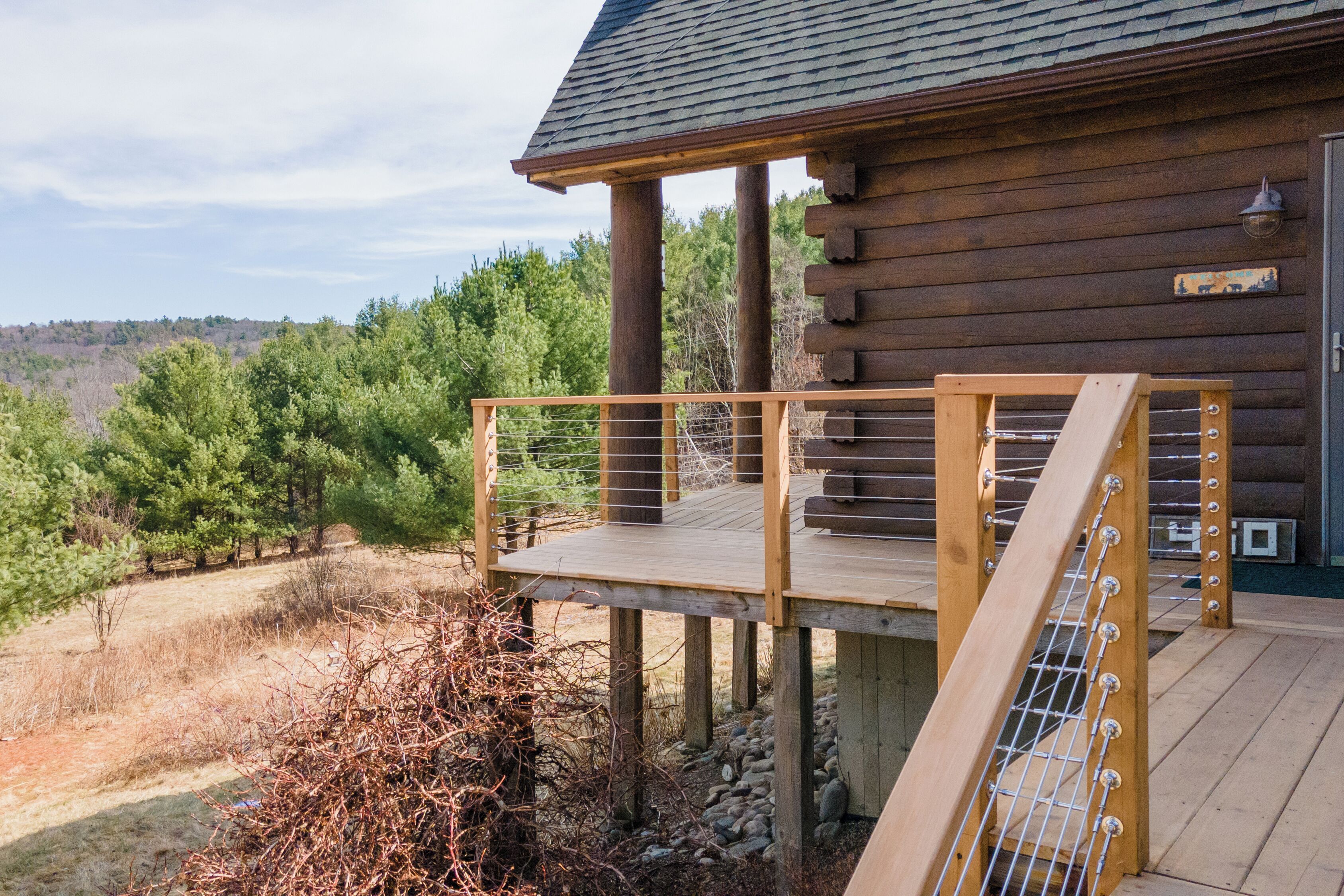 Eine Holzhütte mit einer Holzterrasse und einem Metallgeländer.