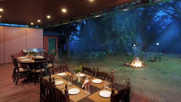 Un comedor interior con vista a un bosque de noche.