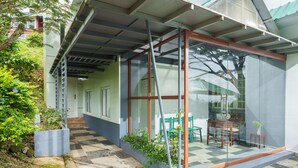 Un edificio moderno con cerramiento de vidrio, asientos al aire libre y suelo a cuadros.