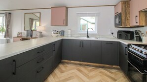 Una cocina moderna con una isla central, armarios oscuros, un microondas y una estufa.
