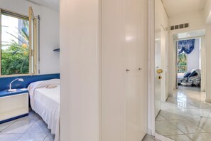 A bedroom with a bed, bedside table, and a wardrobe.