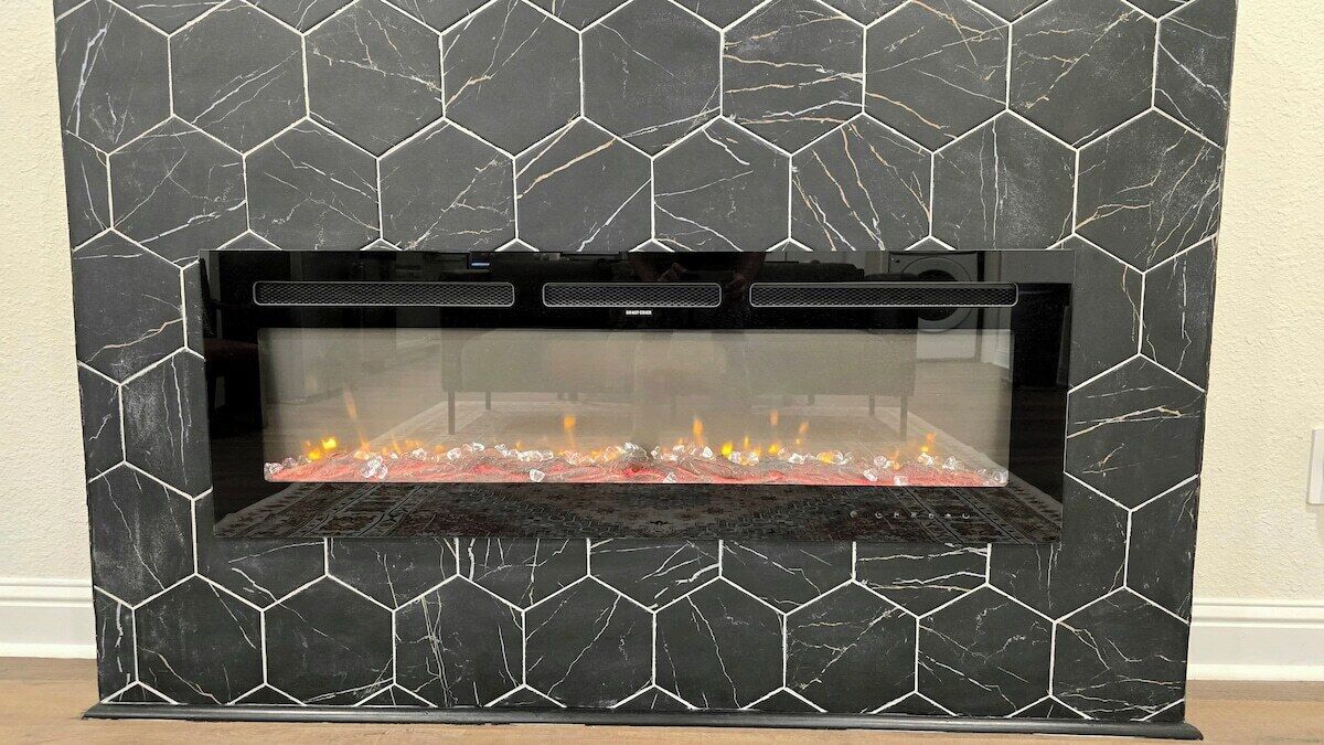 A fireplace with a black marble pattern and a glass front.