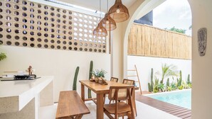 Un espacio interior moderno con piscina, muebles de madera y una pared decorativa con círculos.