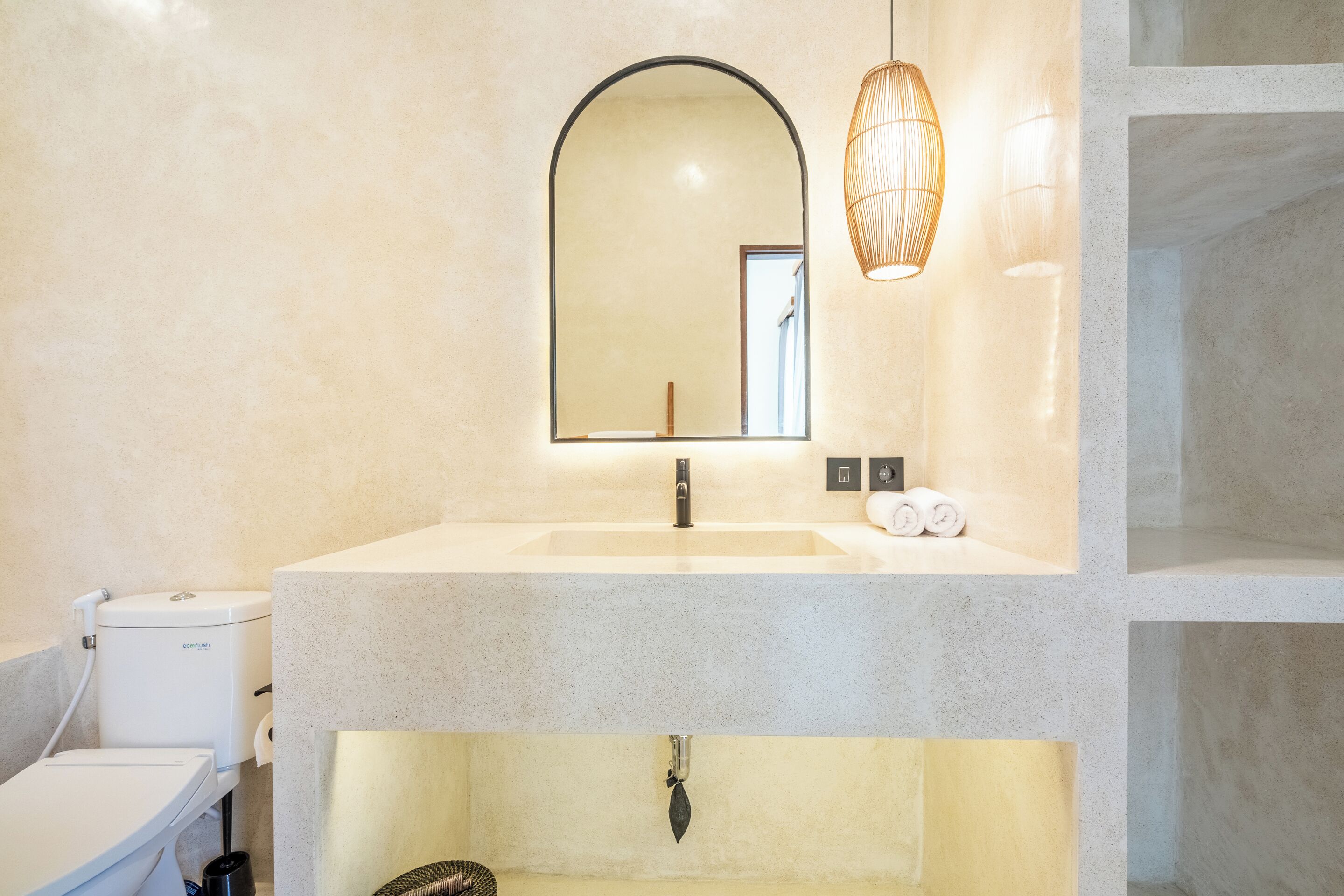 A bathroom with a large mirror, a sink, and a toilet.
