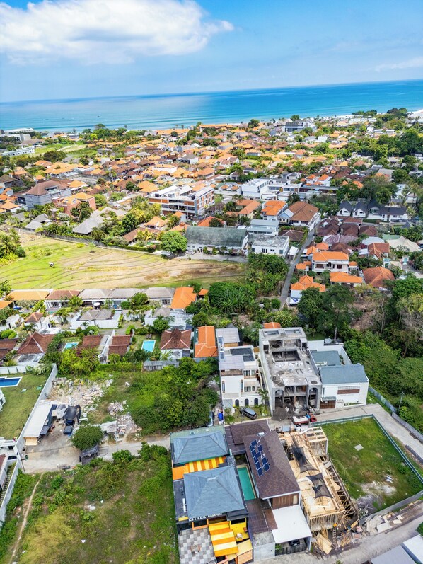Vista aérea de una zona residencial con casas, un sitio de construcción y una vista despejada del océano.
