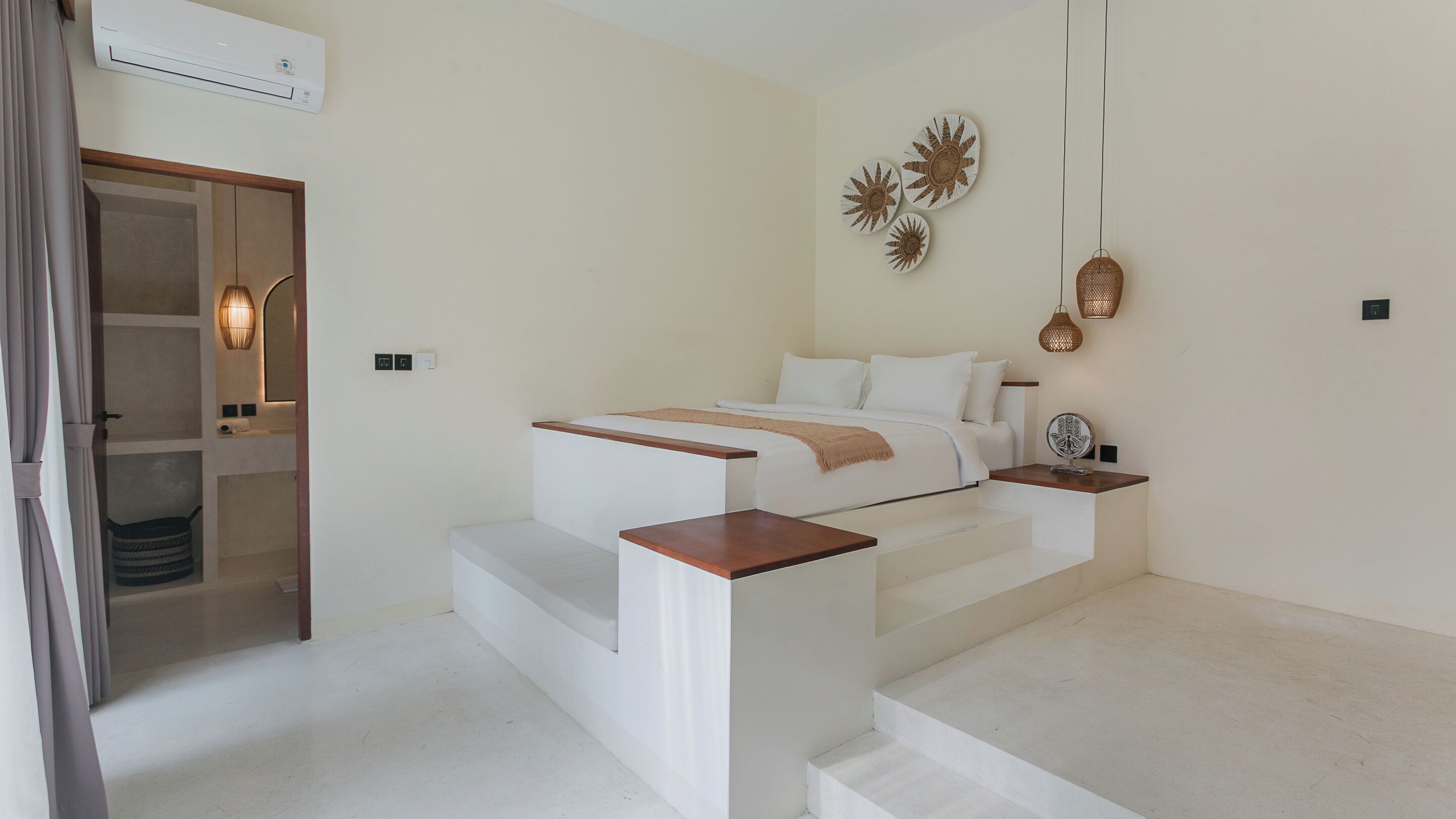 Une chambre à coucher moderne avec un lit, des tables de chevet, un miroir et un escalier.