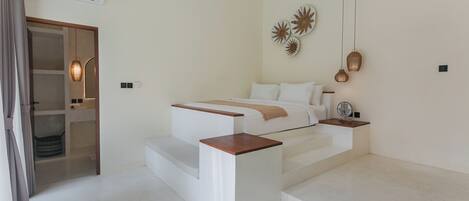 Une chambre à coucher moderne avec un lit, des tables de chevet, un miroir et un escalier.