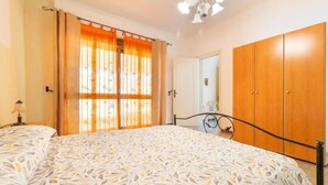 A bedroom with a bed, a wardrobe, and a window with curtains. - Terrace House by the Sea, Ac, Torre Lapillo (Torre Lapillo)