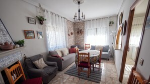 A living room with a fireplace, a dining table with chairs, a sofa, and a grey couch. - We have ski slopes. The hike up to La Covatilla takes 5 minutes. (San Bartolomé de Béjar)