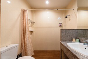 Un baño con inodoro, ducha y lavamanos.