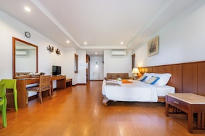 Una habitación de hotel con cama, escritorio, silla y televisor.