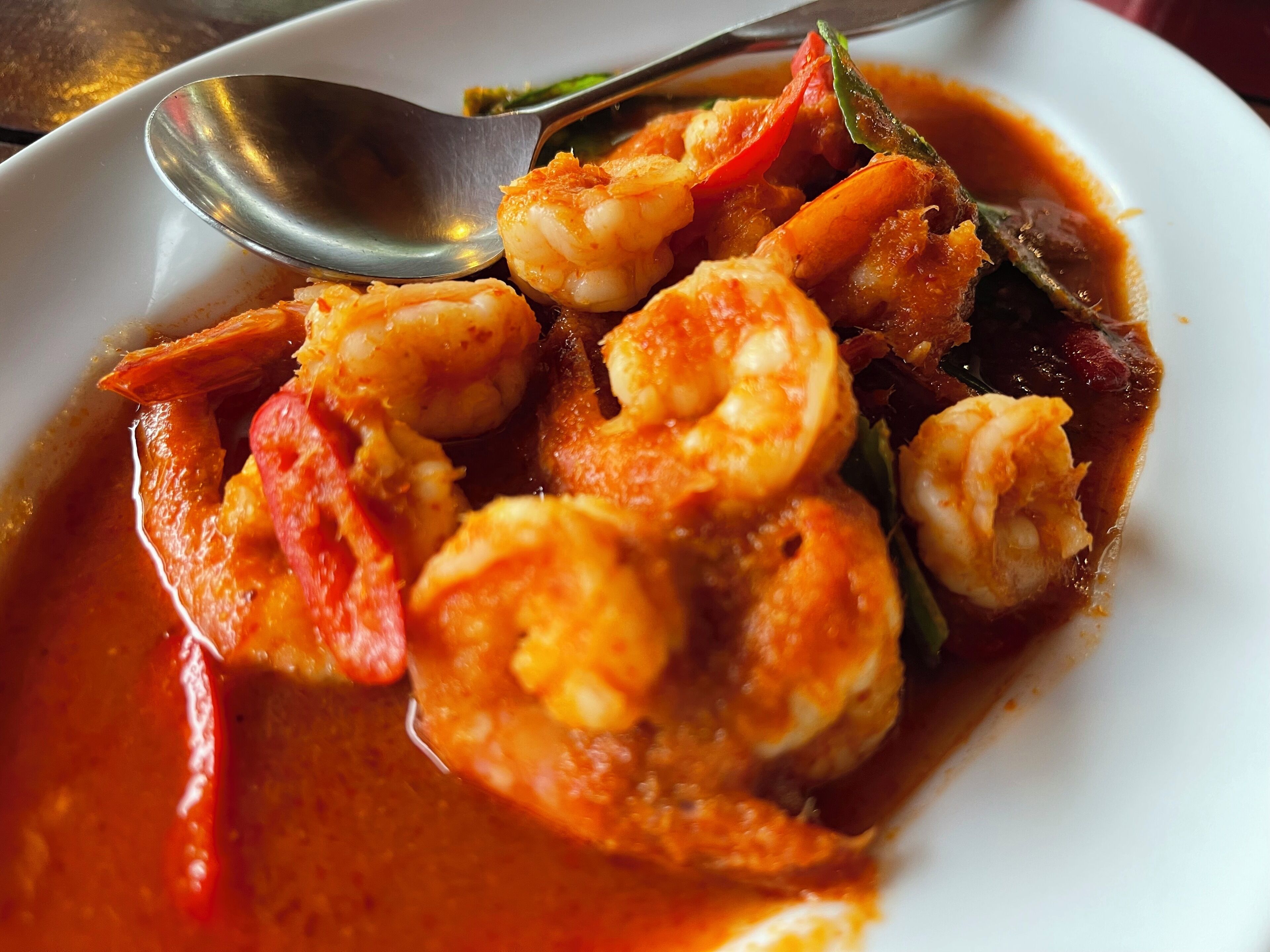 A dish with shrimp and vegetables in a red sauce.