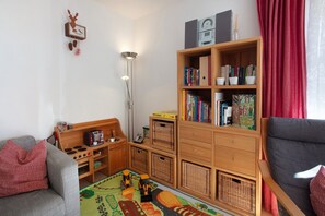 A cozy living room with a sofa, a bookshelf, a coffee table, and a floor lamp.