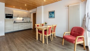 Una cocina moderna con armarios de madera y un comedor con una mesa y sillas.