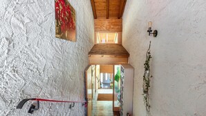 A narrow stairway with a red handrail, wooden ceiling beams, and a view into an adjacent room. - Apartment Hedi, 35 sqm with Mountain View, Balcony and Wi-Fi (Todtnau)