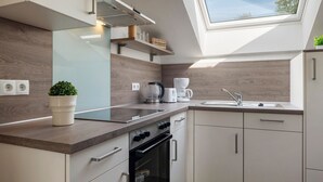 Eine moderne Küche mit Oberlicht, eingebautem Backofen und weißen Schränken.